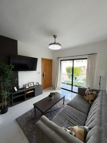 ein Wohnzimmer mit Sofa und Fernseher in der Unterkunft Oasis Costa Cana in Punta Cana in Punta Cana