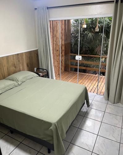 a bedroom with a bed and a balcony at Casa no Centrinho para 2 pessoas 100m do Mar in Bombinhas