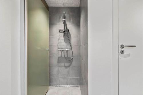 une salle de bain avec une douche avec une porte vitrée dans l'établissement 9951-Hvide-Sande-Langsand-206, à Hvide Sande