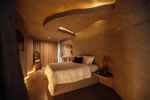 een slaapkamer met een groot bed in een kamer bij Eos Wellness by Amazonia in Tulum