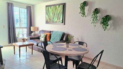 un soggiorno con un tavolo e un divano di Casa Veta Qro a Villa del Pueblito