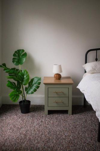 ein Schlafzimmer mit einem Tisch mit einer Lampe und einer Anlage in der Unterkunft Cozy home in Kings Lynn