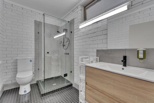 a bathroom with a shower and a toilet and a sink at Snobs Creek Motel Eildon in Eildon