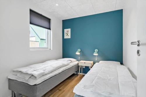 une chambre avec deux lits et un mur bleu dans l'établissement 943-Hvide-Sande-Langsand-165, à Hvide Sande