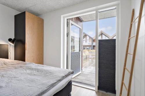 een slaapkamer met een bed en een glazen schuifdeur bij 908-Hvide-Sande-Langsand-102-stuen in Hvide Sande
