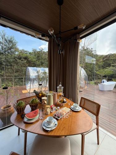 a wooden table in a room with a large window at Cabana Bolha Realeza in Manhuaçu