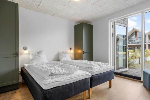 En eller flere senge i et værelse på 912-Hvide-Sande-Langsand-188-stuen