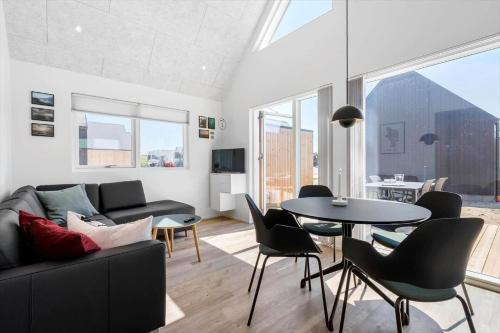 een woonkamer met een bank, een tafel en stoelen bij 944-Hvide-Sande-Langsand-143 in Hvide Sande