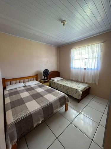 a bedroom with two beds and a window at Recanto do descanso in Pinhal