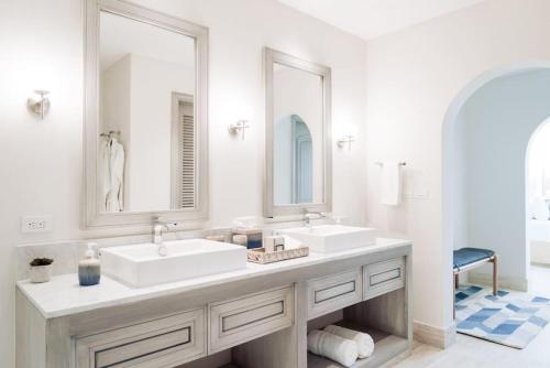 a white bathroom with two sinks and two mirrors at Luxury Villa Retreat, Pool in Cabo San Lucas