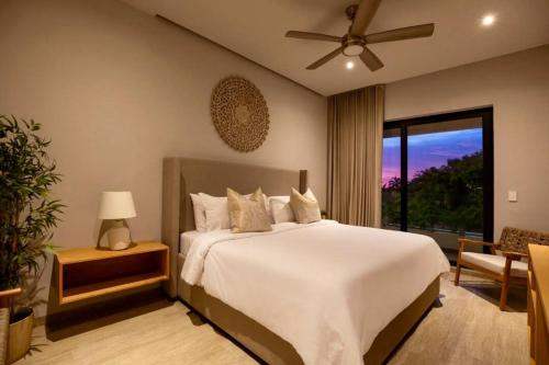 a bedroom with a large white bed and a window at CASA 1111 SMALL in Mazatlán