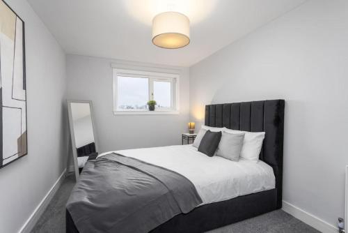 a bedroom with a large bed with a black headboard at Well Presented 3 Bedroom, Grangemouth. in Falkirk