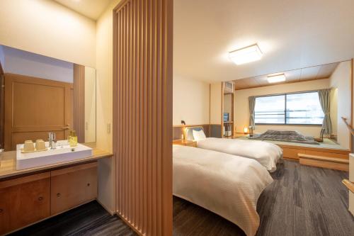 a hotel room with a bed and a sink at ShirabuOnsen Higashiya in Yonezawa
