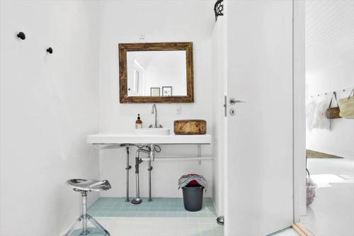 een badkamer met een wastafel, een spiegel en een kruk bij 2029-Stege-Telefonstien-41 in Stege