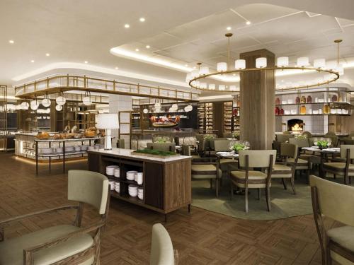 ein Restaurant mit Tischen und Stühlen und einem Buffet in der Unterkunft The Ambassador Seoul - A Pullman Hotel in Seoul