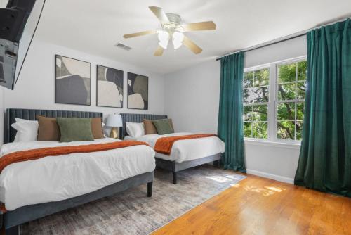 a bedroom with two beds and a ceiling fan at Modern 3BR Near NYC with Pool Table Sleeps 11 in Jersey City