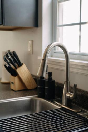 a kitchen counter with a sink and a knife block at Modern 3BR Near NYC with Pool Table Sleeps 11 in Jersey City