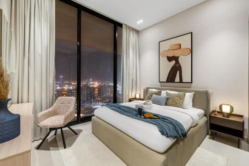 a bedroom with a large bed and a large window at Stylish 1BR with Private Pool Near Circle Mall in Dubai