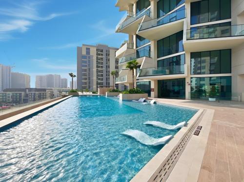 a swimming pool in front of a building at Stylish 1BR with Private Pool Near Circle Mall in Dubai