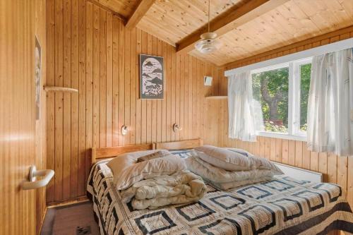 a bedroom with a bed in a room with wooden walls at 5011-Askeby-Faergensvaenge-17 in Askeby