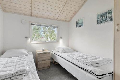 zwei Einzelbetten in einem Zimmer mit Fenster in der Unterkunft FA037 Faxe Ladeplads - Strandlodden 54 in Fakse Ladeplads