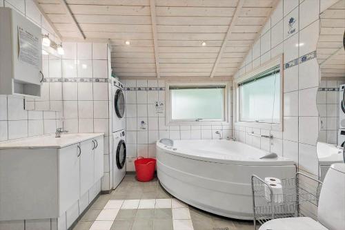 ein weißes Badezimmer mit Badewanne und Waschbecken in der Unterkunft FA037 Faxe Ladeplads - Strandlodden 54 in Fakse Ladeplads