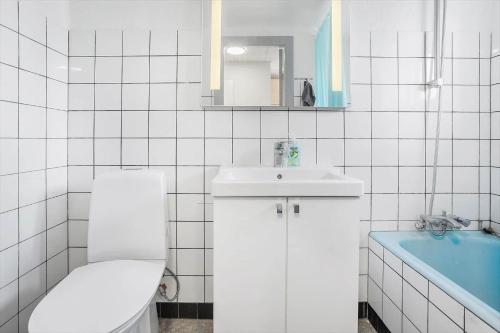 een witte badkamer met een toilet en een wastafel bij 4231-Stege-Nymarksvej-21 in Stege