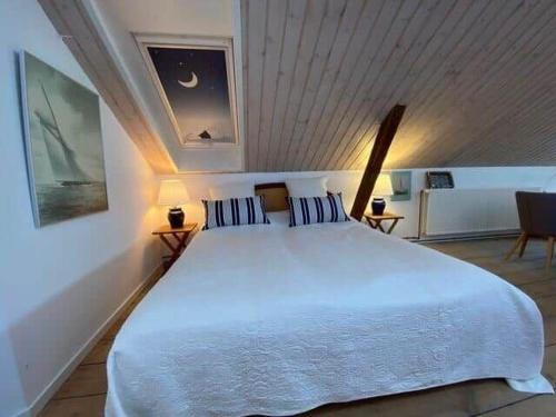 una camera da letto con un grande letto bianco in una stanza di 4264-Stege-Storegade-64-Baghuset a Stege