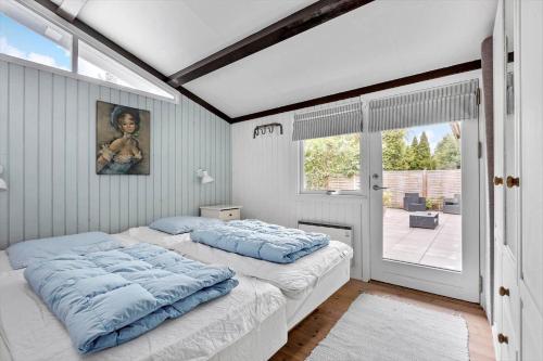 a bedroom with a bed with blue sheets and a window at 3006-Stege-Bunden-6 in Stege