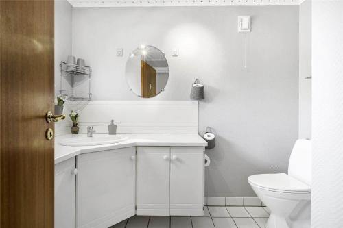 een witte badkamer met een wastafel en een toilet bij S740-Stroby-Ladeplads-Lovsangervej-33 in Strøby Ladeplads
