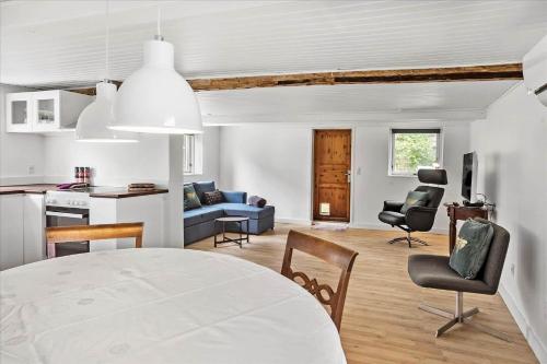 een keuken en een woonkamer met een tafel en stoelen bij 4320-Stege-Oddermose-Strandvej-5-B in Stege