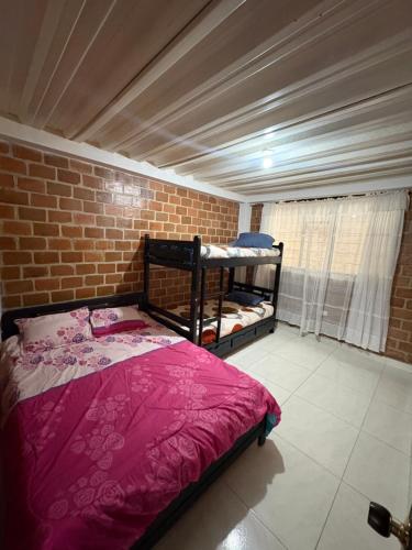 a bedroom with a bed and a brick wall at Finca Cimarrones Robles 