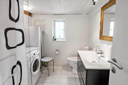 een witte badkamer met een wastafel en een koelkast bij 4320-Stege-Oddermose-Strandvej-5-B in Stege