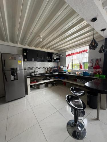 een keuken met een koelkast en een tafel en stoelen bij Finca Cimarrones Robles 