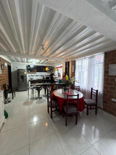 een woonkamer met een tafel en stoelen en een keuken bij Finca Cimarrones Robles 