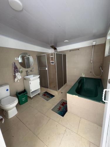 a bathroom with a tub and a toilet and a sink at Finca Cimarrones Robles 