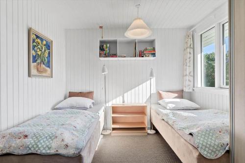 een slaapkamer met twee bedden en een raam bij 8205-Vordingborg-Strandparken-12 in Vordingborg