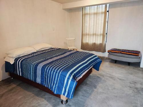 een slaapkamer met een bed, een stoel en een raam bij Posada el Pino 