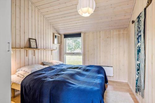una camera con letto blu in una stanza con finestra di 1054-Stege-Ternevej-14 a Stege