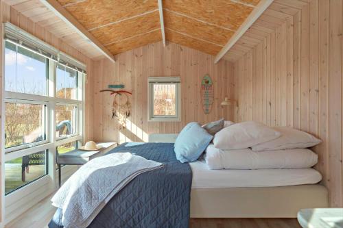 een slaapkamer met een bed in een kamer met houten wanden bij 3307-Stege-Maegleren-7 in Stege