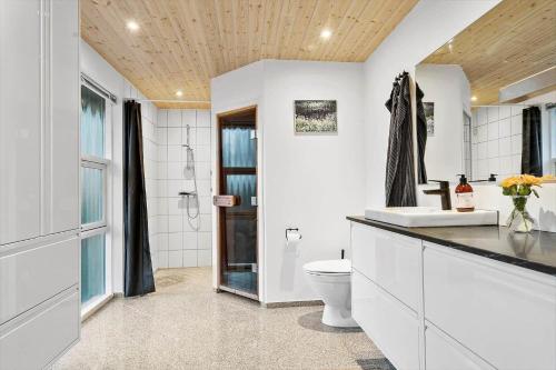 een witte badkamer met een toilet en een wastafel bij 2305-Stege-Thujavej-2 in Stege