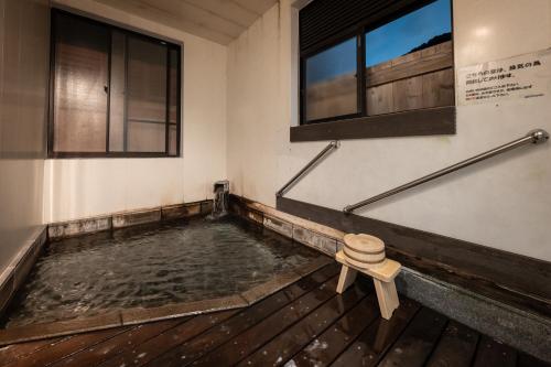 a pool of water in a room with windows at ShirabuOnsen Higashiya in Yonezawa