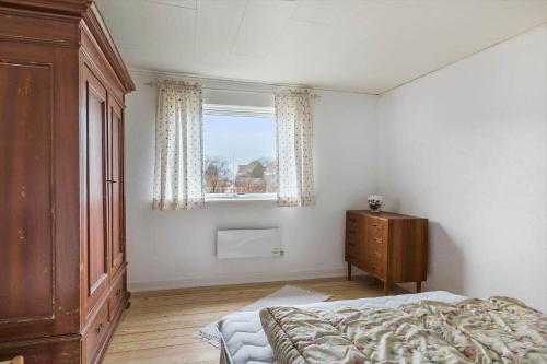 een slaapkamer met een bed, een ladekast en een raam bij 4010-Borre-Thyravej-28 in Borre