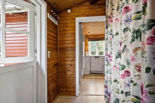 un corridoio che conduce a una cucina con pareti in legno e una finestra di 3032-Stege-Ankeret-4 a Stege