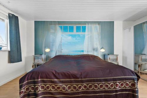 een slaapkamer met een groot bed en een raam bij S718-Stroby-Svalemosevej-18 in Strøby