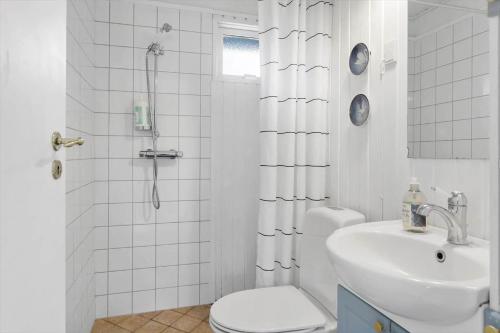 een witte badkamer met een toilet en een wastafel bij 3047-Stege-Paelen-1 in Stege