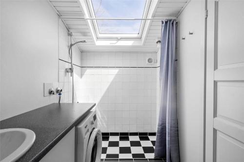 een badkamer met een wastafel en een douche met een raam bij 8207-Vordingborg-Strandparken-22 in Vordingborg