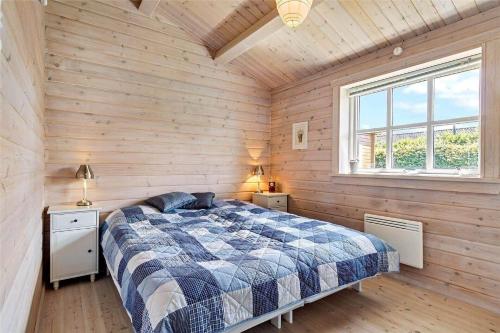 una camera da letto con un letto in una parete di legno di FA035-Faxe-Ladeplads-Strandlodden-9 a Fakse Ladeplads