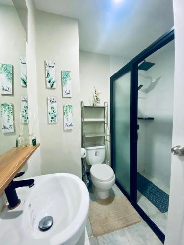 a bathroom with a white toilet and a sink at Amani Grand Resort Residences Pool Netflix Gym near Airport in Lapu Lapu City
