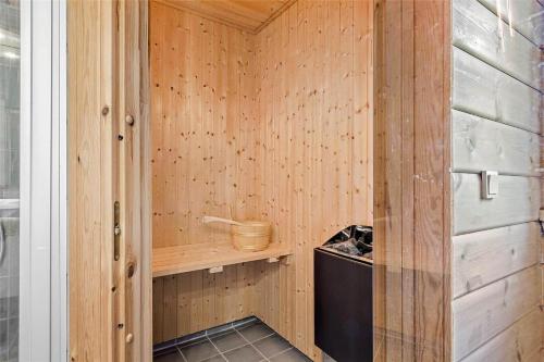 una sauna con una parete di legno e un secchio al suo interno di FA035-Faxe-Ladeplads-Strandlodden-9 a Fakse Ladeplads